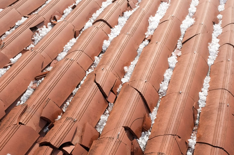 Hagelschaden an den Ziegeln eines Häuserdachs